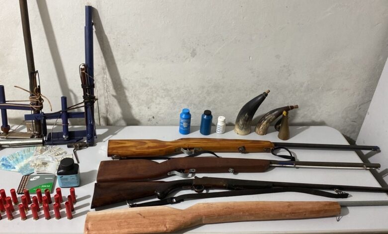 Material apreendido na casa do homem. Foto das armas e munições que a PM apreendeu.
