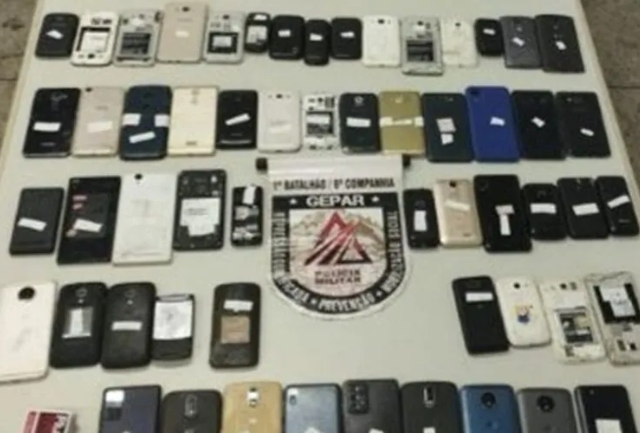 Suspeitos foram flagrados com sacola cheia de aparelhos de procedência duvidosa em shopping popular. Foto dos itens apreendidos.