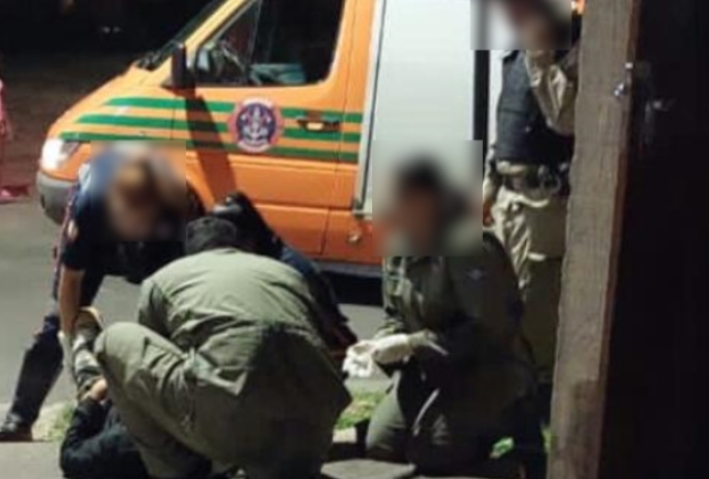 Polícia Militar identifica e procura os autores do crime que aconteceu no bairro Cohab. Foto dos agentes prestando socorro a vítima.