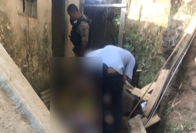 Jovem de 23 anos foi encontrado morto na entrada de uma casa na Rua Santana. Polícia suspeita de acerto de contas e procura por pistoleiro. Foto momentos após o crime.
