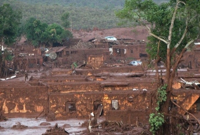 Empresas responsáveis pela tragédia, Vale, BHP e Samarco, interrompem negociações para reparação dos danos socioambientais e econômicos, deixando 2,5 milhões de cidadãos e 49 municípios em incerteza. Foto da tragédia.
